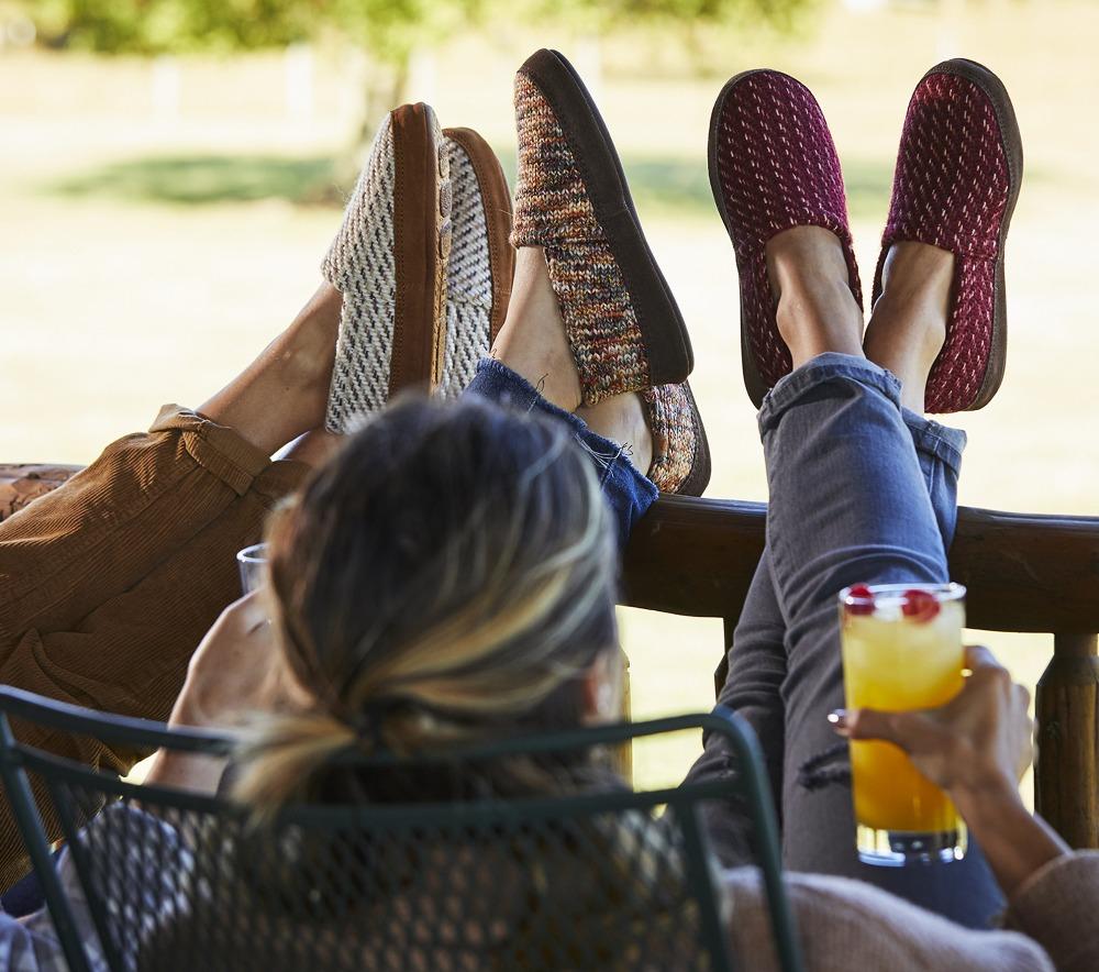 Women’s Original Acorn Moccasins in Ewe, Garnet and Sunset all on model with their feet up on the porch fence #color_brown-and-pink-leaves