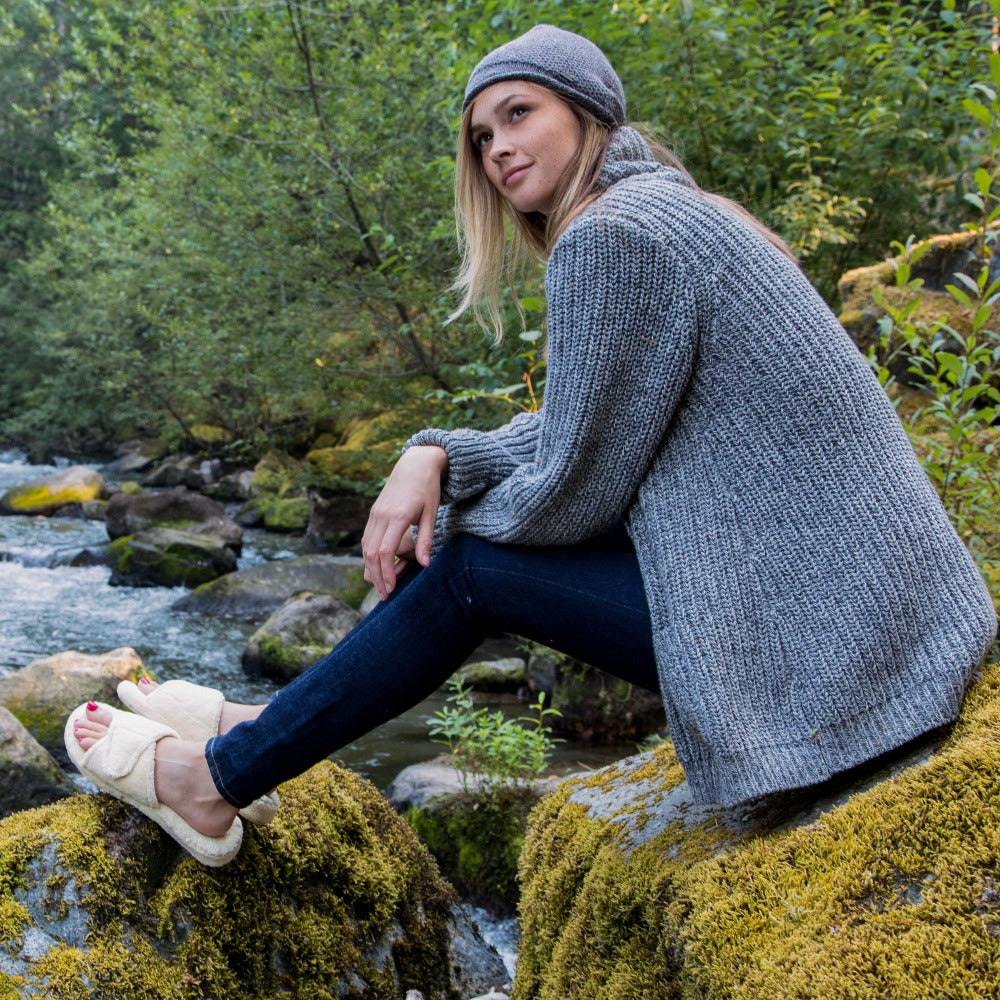 Women's Spa Slide Slippers in Natural On Model Sitting on River Rocks and Moss#color_natural
