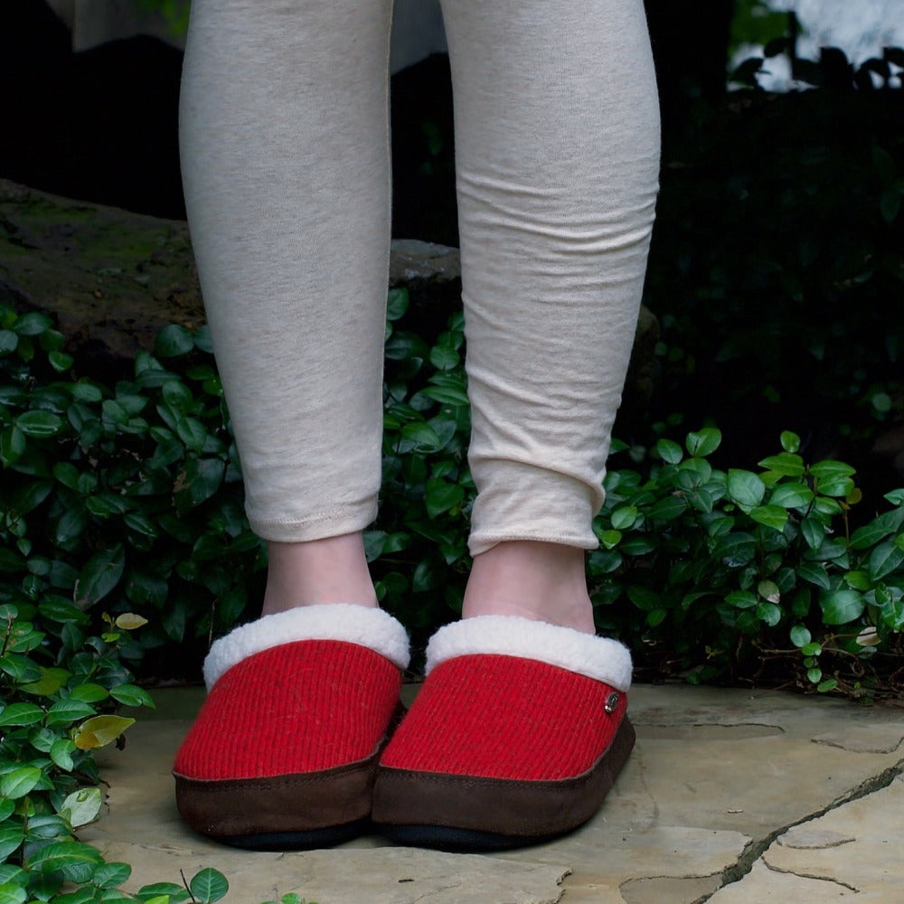 Women's Mule Ragg Slippers on figure standing outside around bright green leaves#color_dark-charcoal-heathered