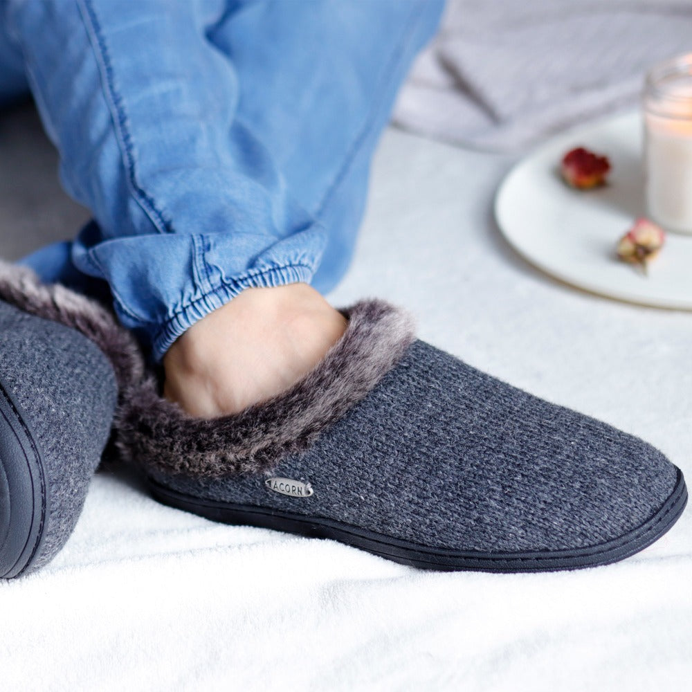 Acorn Women's Faux Fur Chinchilla Rag in Dark Charcoal on figure. Model sitting on a comfy blanket with their legs crossed at the ankle. A candle is in the background#color_dark-charcoal-heathered