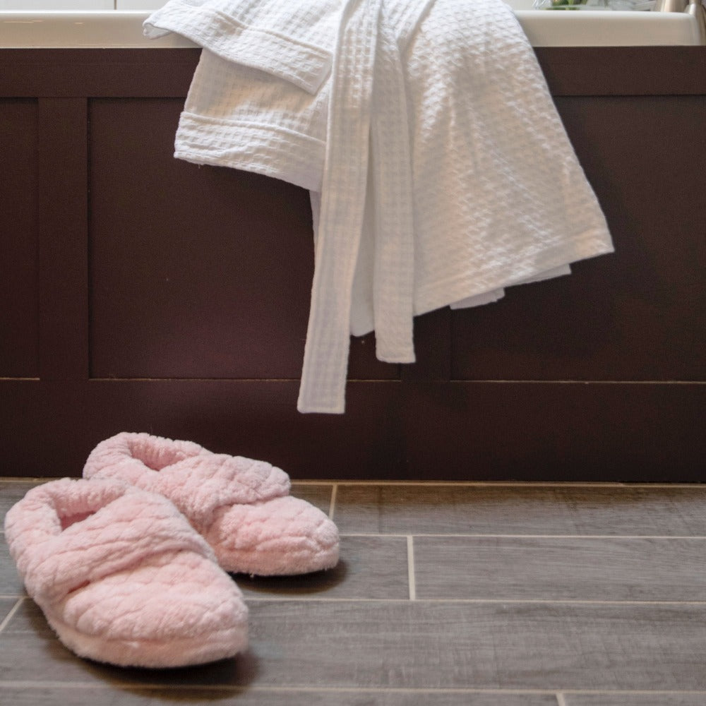 Women's Adjustable Spa Wrap Slippers in pink off figure sitting in front of bath tub#color_pink
