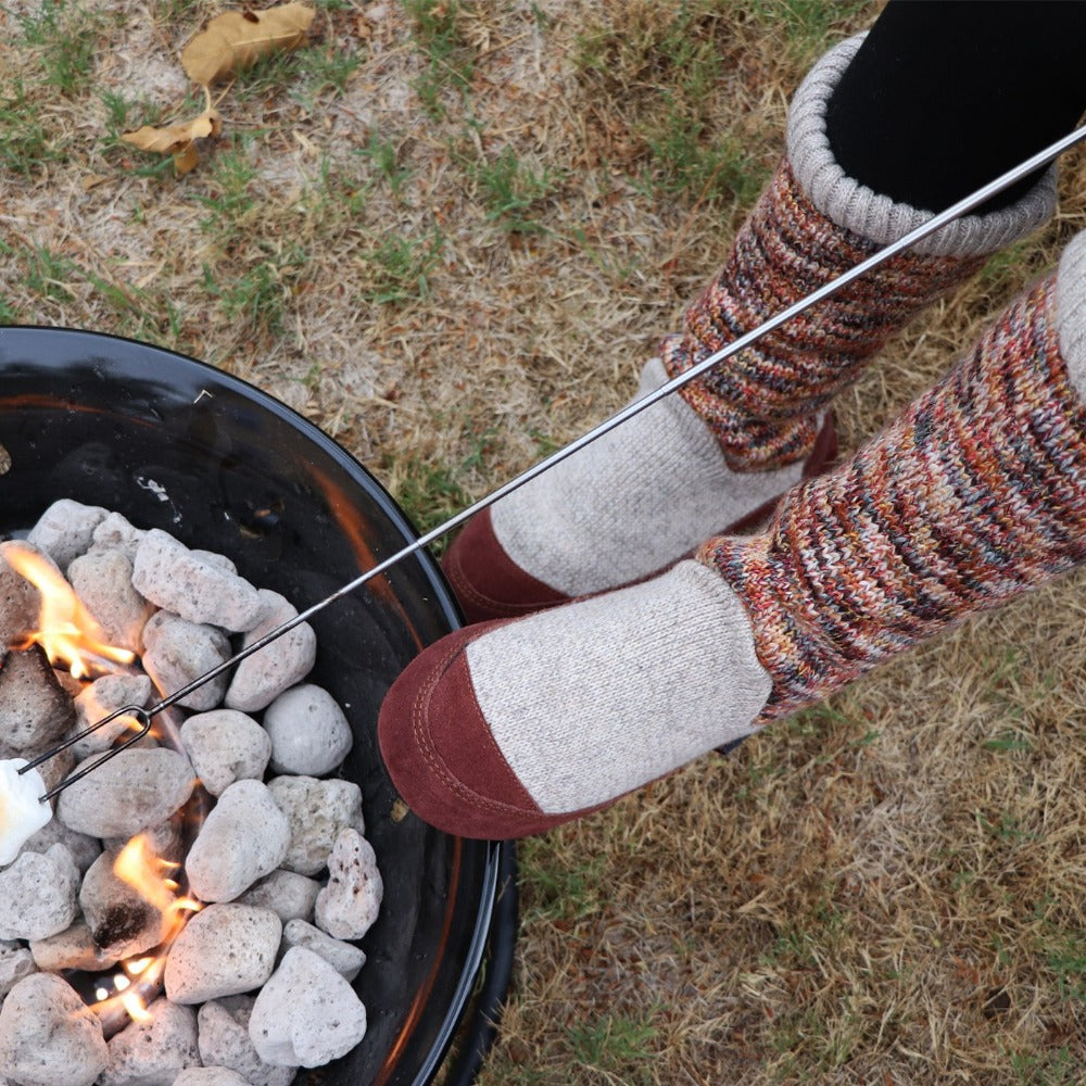 Women's Slouch Boots in Sunset Cable Knit On Model Roasting Marshmallows Over a Fire #color_sunset-cable-knit